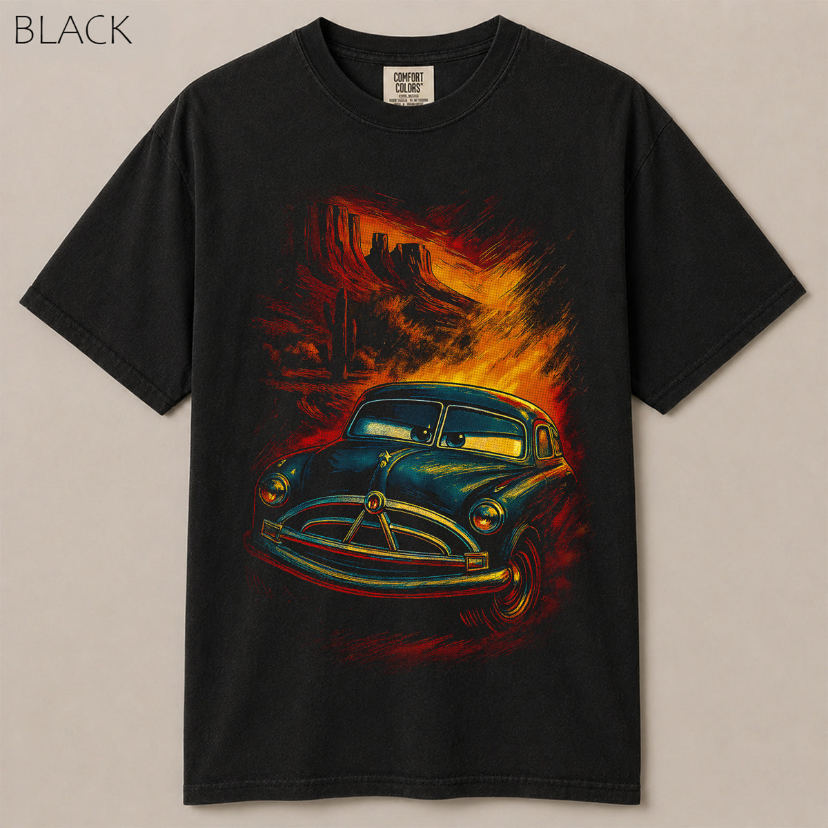 Radiator Springs Doc Hudson desert shirt. Vintage blue race car in Monument Valley sunset, Route 66 Cars movie tee on soft garment-dyed black cotton.